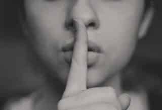 grayscale photo of woman doing silent hand sign