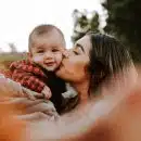 woman kiss a baby while taking picture