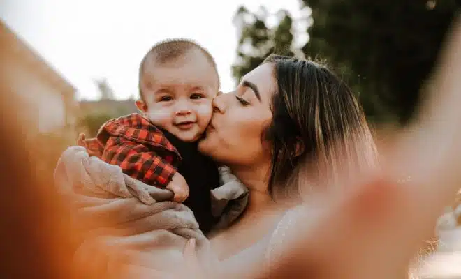 woman kiss a baby while taking picture