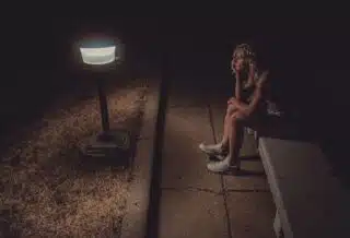 woman in black tank top sitting on concrete floor