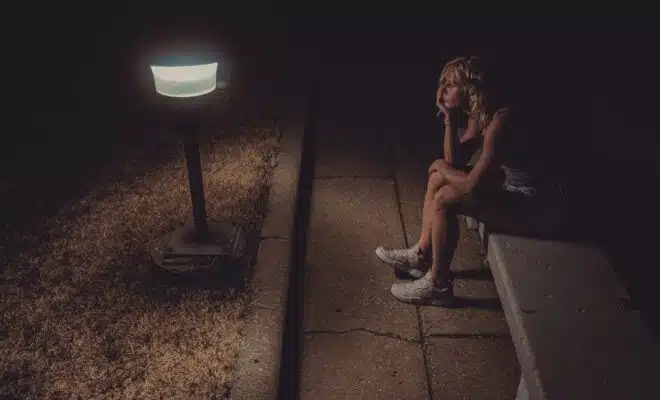 woman in black tank top sitting on concrete floor